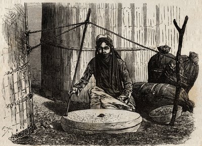 Femme turcomane utilisant la meule à grains, activant un ingénieux système de manivelle, la pierre supérieure tourne et en frottant cette pierre sur l