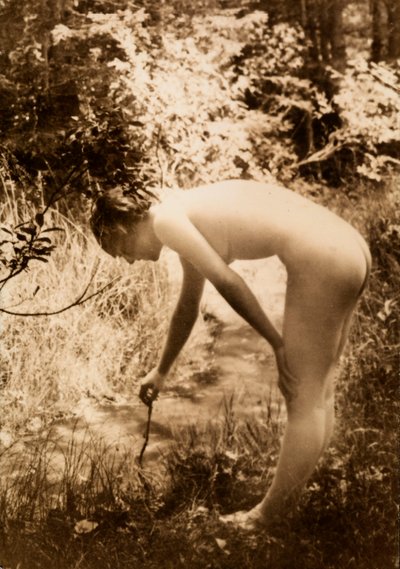 Une jeune femme, nue dans les bois, vue de profil alors qu
