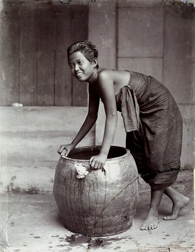 Jeune femme thaïlandaise souriante, poussant un grand conteneur - Unknown photographer