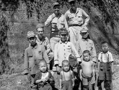 Soldats américains avec une famille japonaise posant ensemble après la reddition japonaise - Volkmar Wentzel
