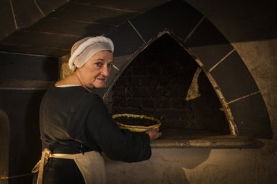 Reconstitution historique : Servante mettant un gâteau au four de la cuisine du château - John Ward Dunsmore