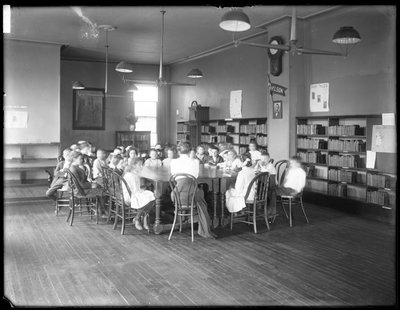 Des enfants écoutent une femme dans la salle de lecture d