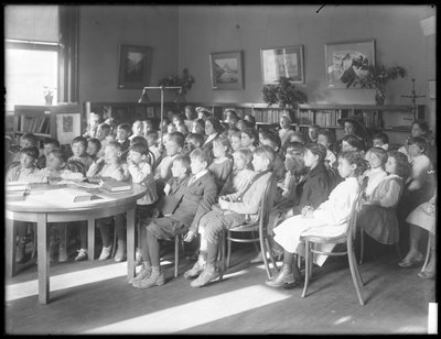 Enfants assis, écoutant dans la salle de lecture d