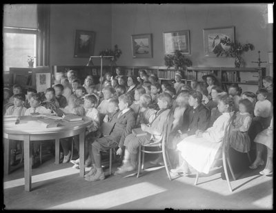 Enfants assis, écoutant dans la salle de lecture d