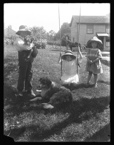 Enfants avec un chien et un chiot rassemblés autour d
