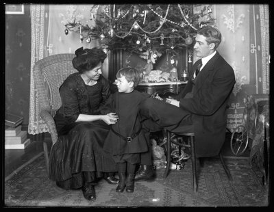 Dan Seymour et sa famille en pose informelle, assis sous un sapin de Noël, Noël 1912 - William Davis Hassler