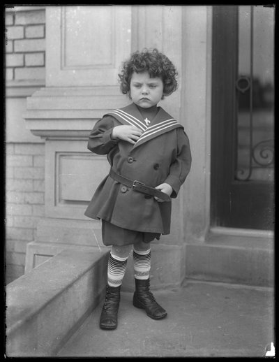 Petit garçon en costume de marin sur le perron de l