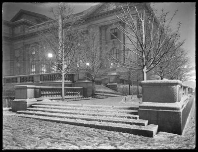 Vue nocturne du coin nord-est des marches devant la branche principale de la bibliothèque publique de New York sous la neige, 42nd Street et Fifth Avenue, New York City, 6 mars 1915 - William Davis Hassler