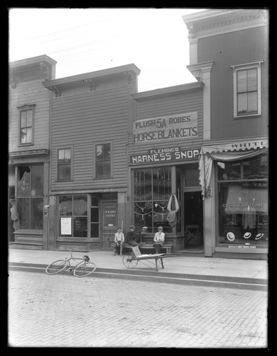 Trois garçons non identifiés devant la boutique de harnais de Fleming, peut-être Cochranton, Pennsylvanie, vers 1913 - William Davis Hassler