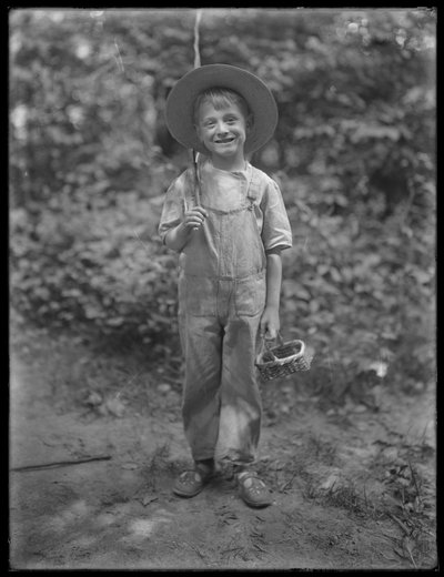 William Gray Hassler en chapeau de paille et salopette, portant une canne à pêche et un panier dans les bois, 20 août 1911 - William Davis Hassler