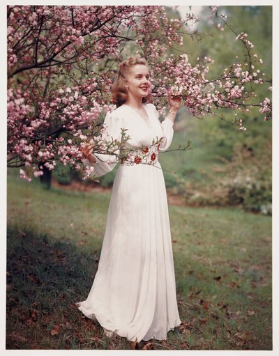 Femme modélisant une robe près des fleurs, vers les années 1940 - Frederick (attr. to) Barnard