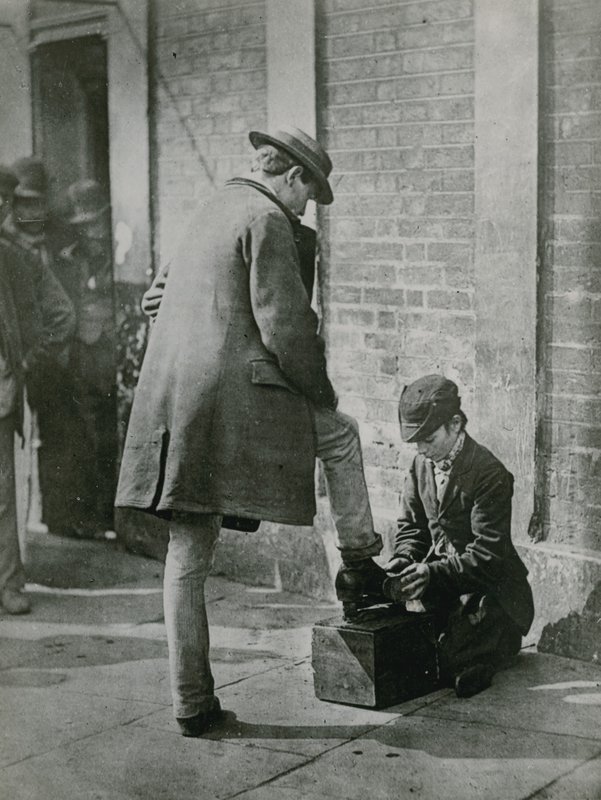 Un jeune cireur de chaussures cirant les chaussures d
