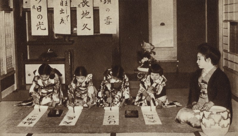Écolières japonaises écrivant avec des pinceaux dans une classe de maternelle (photo n/b) - Photographer Japanese