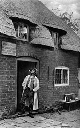 Un homme fumant une pipe devant un magasin, Worcestershire