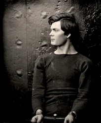 Lewis Powell avec des fers aux poignets à bord de l