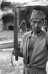 TRANSFORMATION DU CHANVRE, UN OUVRIER AVEC UNE "SPATULE"