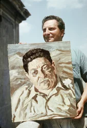 Le peintre et écrivain italien Carlo Levi (1902-1975) tenant l