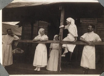 Première Guerre mondiale 1914-1918 : infirmières et médecins en blouse parlant à Couville, Manche, Basse-Normandie, France. Photographie anonyme juillet 1917. Collection privée, Stella.