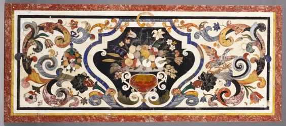 Un plateau de table en pietra dura florentin centré par un bol de fruits et de fleurs
