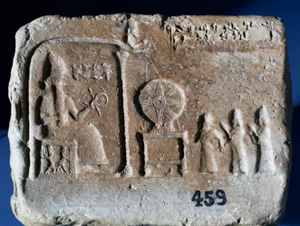 Tablette votive représentant Shamash, le dieu-soleil de Sippar, assis dans son sanctuaire avec le roi babylonien Nebopaliddin conduit en présence du dieu par deux figures. Art babylonien, IXe siècle av. J.-C.