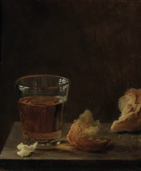 Un verre de bière et un petit pain sur une table