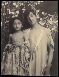 Garçon et fille siciliens devant un textile floral