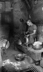 Métallurgiste italien martelant une feuille de métal pour fabriquer un récipient ou un pot, Italie