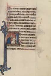 Initiale A : Une noble femme assise par terre en train de lire