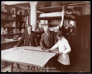 Portrait de Henry et S.G. Lindeman avec leur fils ou petit-fils debout sur des dessins de magasin pour un piano, 1910