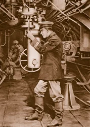Officier de sous-marin britannique examinant le périscope dans l