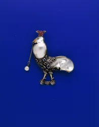 Une broche de la Guild of Handicraft en métal blanc et jaune, en forme de coq « couronné », sertie d