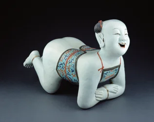 Un oreiller chinois en porcelaine en forme de garçon à demi nu