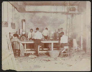 Laboratoires de films chez Carlton Motion Picture Co. avec cinq hommes et une femme travaillant avec des films, épissure, etc., New York
