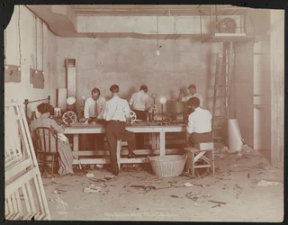 Laboratoires de films chez Carlton Motion Picture Co. avec cinq hommes et une femme travaillant avec des films, épissurage, etc., New York