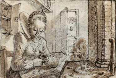 Une jeune femme à la mode assise à une table de cuisine pour écaler des noix
