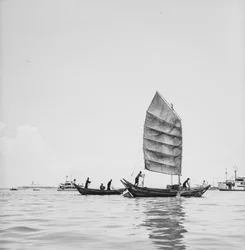 Un sampan sous voile et un autre à la godille dans le port de Penang