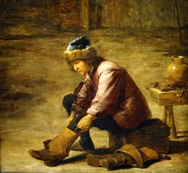 Un jeune homme enfilant une botte