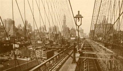 Lower Manhattan vu à travers le réseau de câbles sur le pont suspendu de Brooklyn, vers 1930