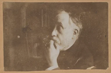 [Autoportrait dans une bibliothèque (main au menton)]