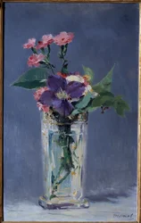 Œillets et clématites dans un vase en cristal