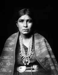 Femme Navajo portant un collier de fleurs de courge en argent, ceinture concho, couverture drapée sur les épaules, vers 1904, photo Edward S. Curtis