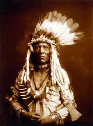Weasel Tail, Piegan, avec une Tomahawk, c. 1900