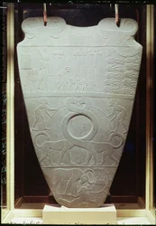 La palette de Narmer : palette cérémonielle représentant le roi Narmer, portant la couronne rouge de Basse-Égypte, inspectant des prisonniers ligotés et décapités, ainsi qu