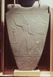 La palette de Narmer : palette cérémonielle représentant le roi Narmer, portant la couronne blanche de la Haute-Égypte, frappant un prisonnier, trouvée à Hieraconpolis, Période dynastique précoce, vers 3000 av. J.-C.