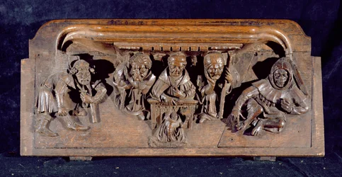 Une miséricorde représentant un académicien assis à un bureau délivrant une admonition à un pénitent agenouillé, New College Chapel, Oxford, fin du 14ème siècle