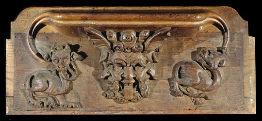 Une miséricorde représentant trois visages humains flanqués de monstres, New College Chapel, Oxford, fin du 14ème siècle