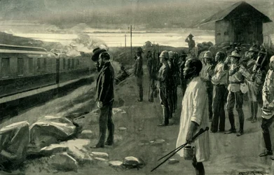Le train transportant les restes de M. Rhodes salué par les gardes du blockhaus
