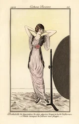 Femme en robe de mousseline de soie lilas avec gilet de velours noir se regardant dans un miroir. Déshabillé de mousseline de soie glycine drapé et bordé de fourrure, petite casaque de velours noir frappé. Eau-forte au pochoir coloriée à la main d