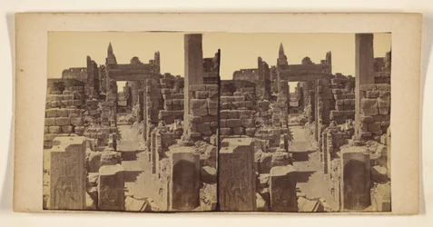 [Ruines avec des figures sculptées sur les murs au premier plan]