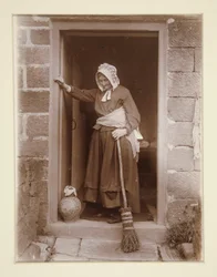 Une vieille dame avec une bouteille de levure à la porte d